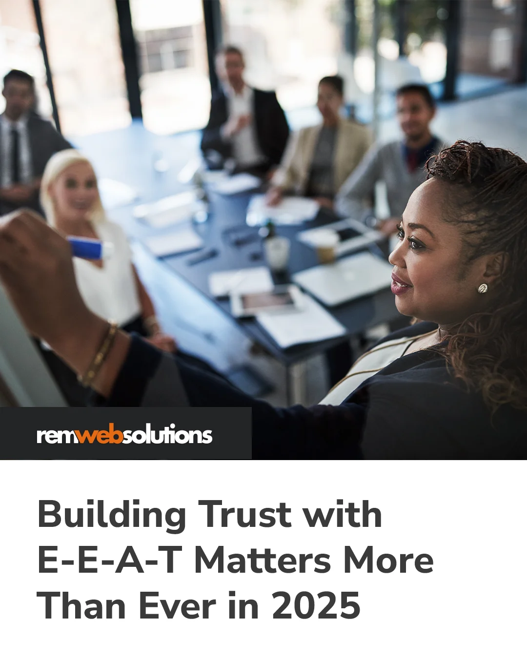 Woman writing on whiteboard in front of staff surrounding board room table
