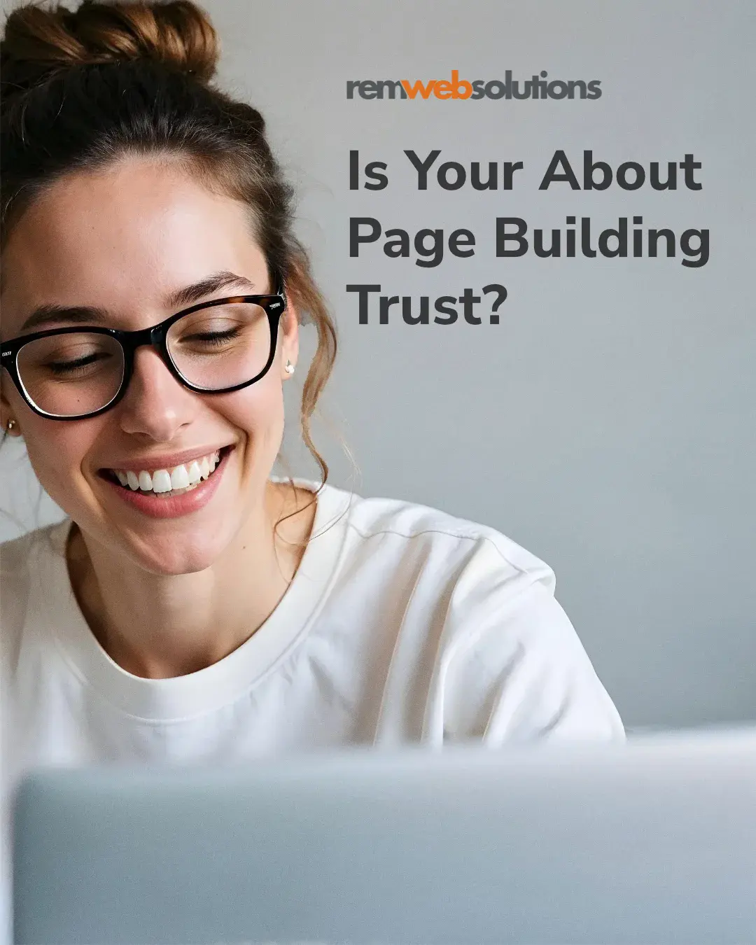 Woman smiling while looking at her laptop.