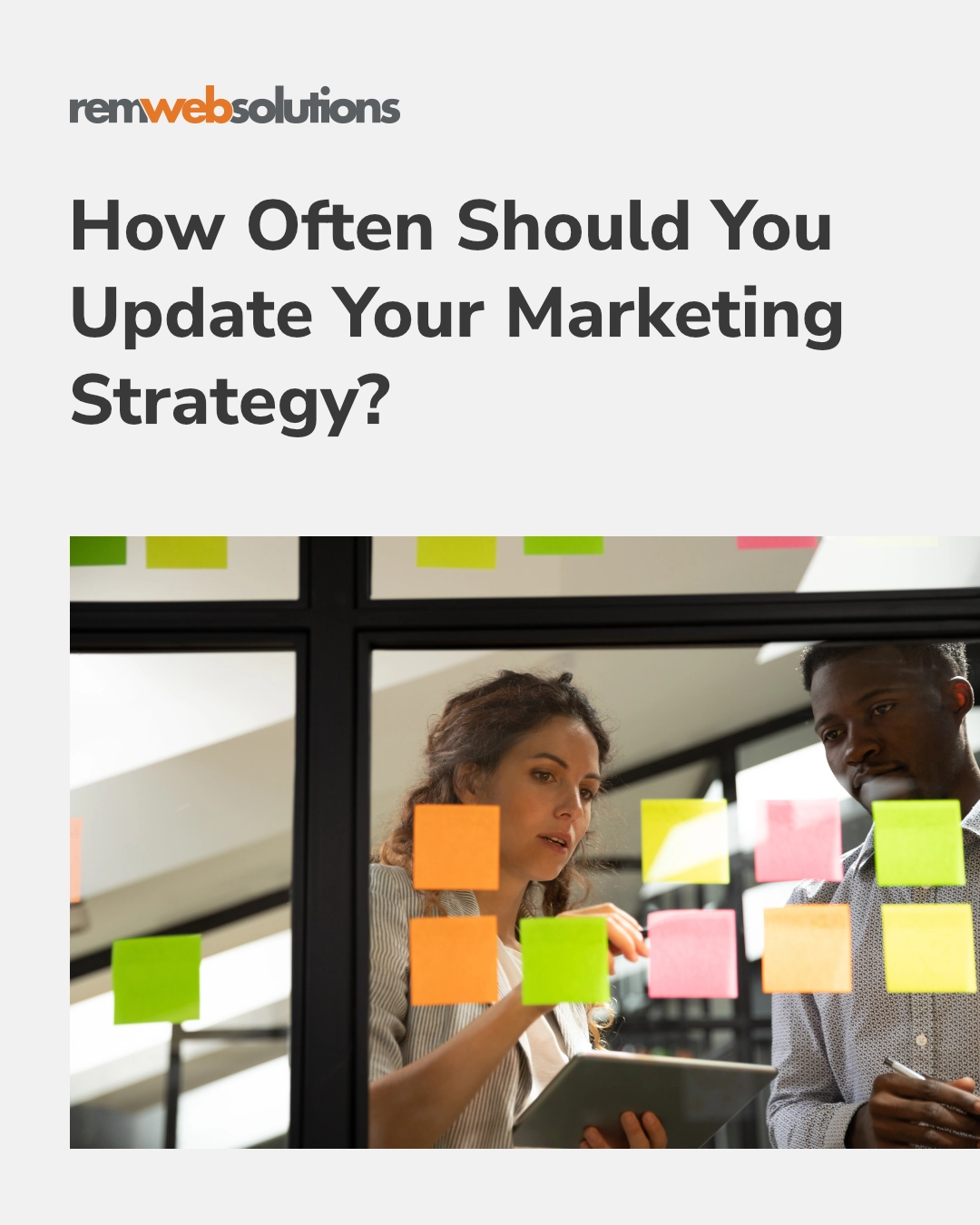 Two employees brainstorming on sticky notes on pane of glass