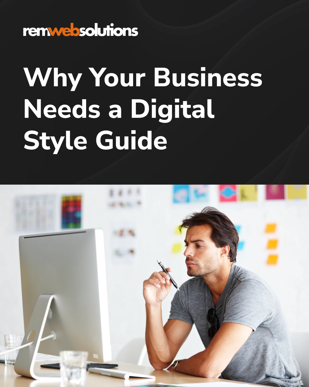 Male employee sitting at desk looking at desktop monitor.