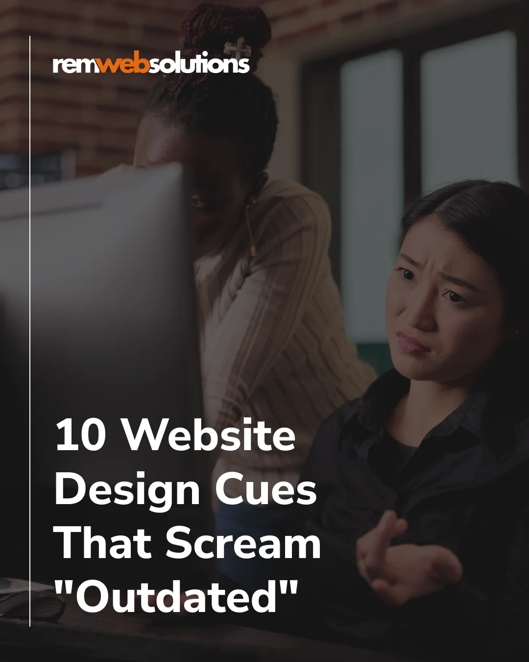 Woman confused on desktop computer alongside co-worker looking over her shoulder.